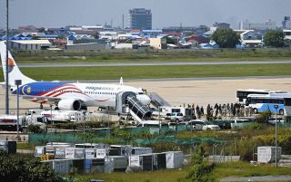 19～52歳の「かけ子」29人は両腕を警察官2人に抱えられ移送機へ…カンボジア特殊詐欺、容疑者となって帰国